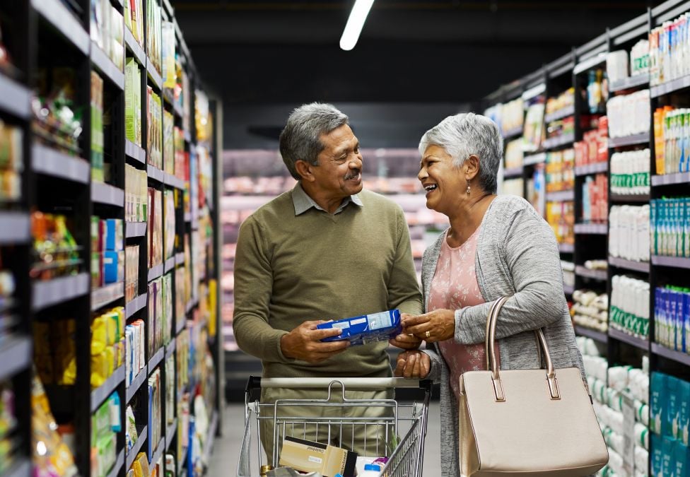 An older couple in a grocery store aisle