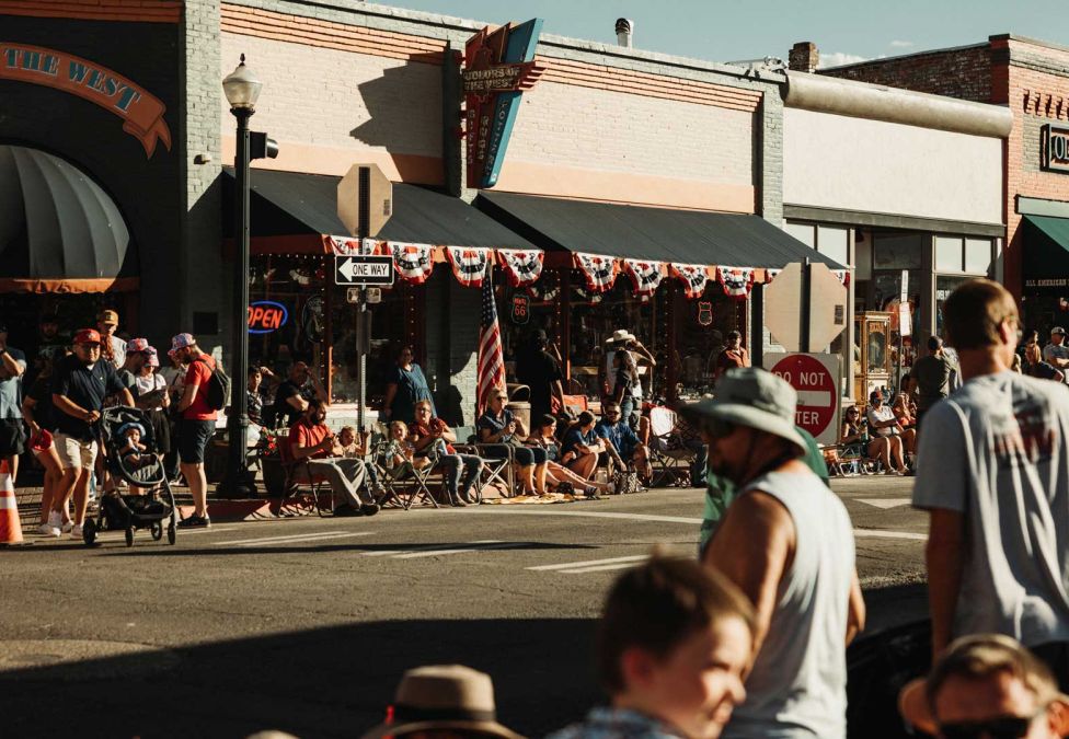 An image of a busy street with shops and buildings and various people.