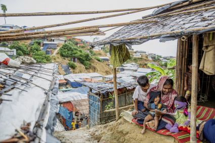 A group of people outside a hut in Bangladesh