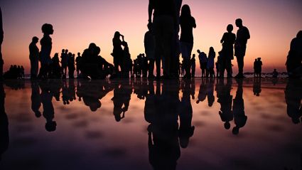 People's silhouettes on a beach during sunset