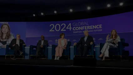 A panel of people speaking at a conference.