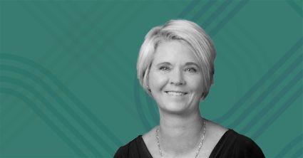 Black-and-white photo of Ginger Gregory, Chief Human Resources Officer at Biogen, smiling against a teal background with abstract line patterns. 