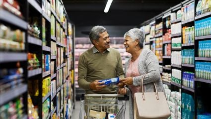 An older couple in a grocery store aisle