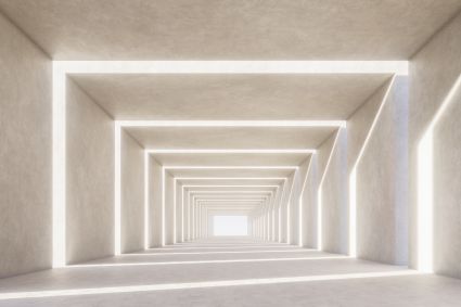 A long minimalist corridor with repeating rectangular archways in warm white concrete, receding toward a bright vanishing point.
