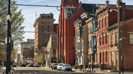 Historic urban street with colorful brick buildings and parked cars on a sunny day