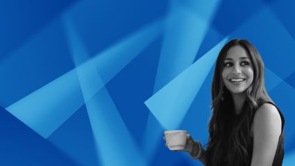 Professional woman holding coffee cup against blue geometric background