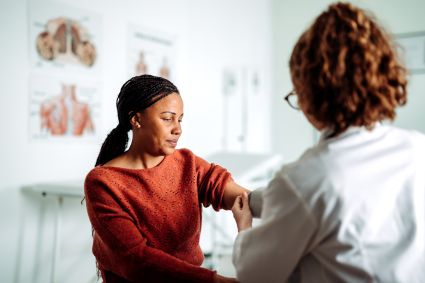 Healthcare worker tending to female patient in clinic office
