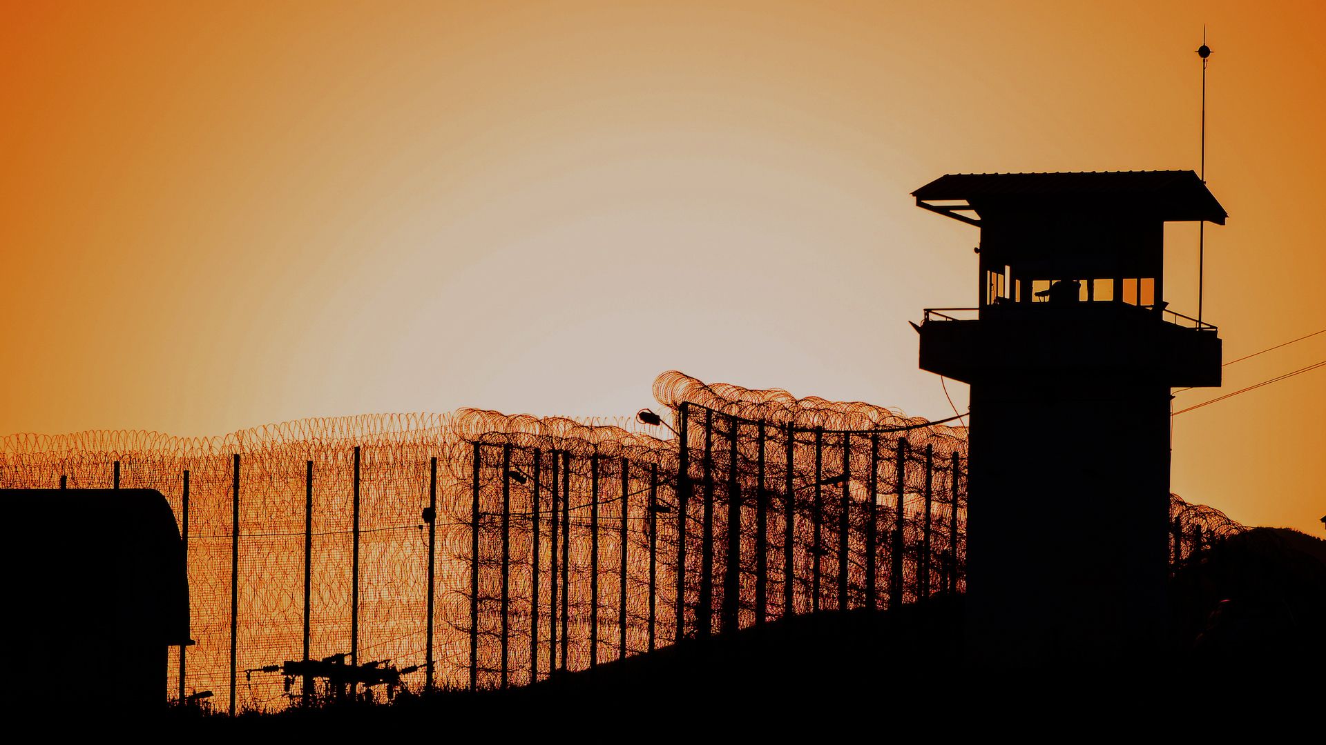 Prison gates and watchtower at dusk