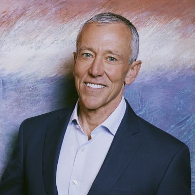 Richard Ditzio, CEO of Milken Institute against blue and white abstract background