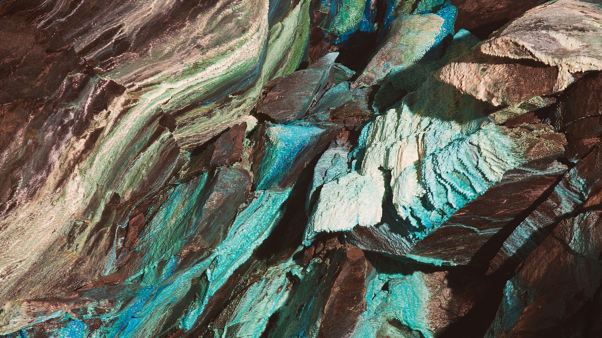 close up of rock with colors of teal, beige, and green, depicting Financial Innovations Labs work at Milken Institute