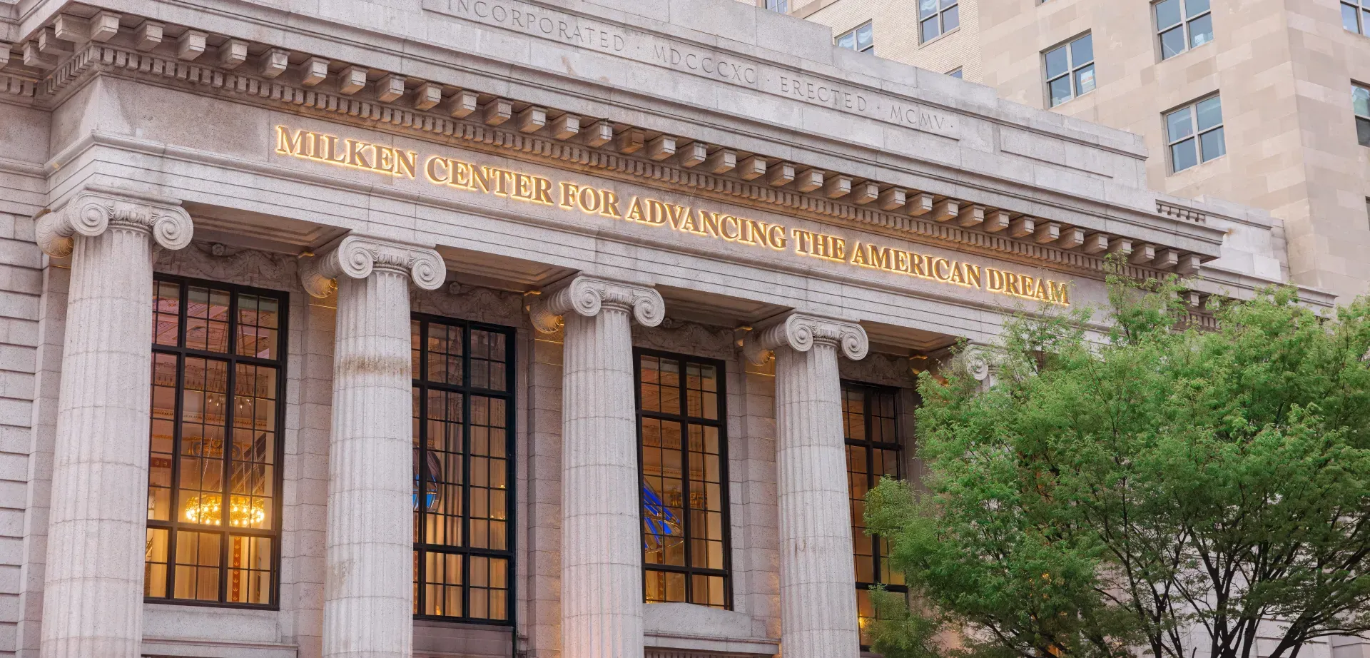 The Milken Center's columned Pennsylvania Avenue facade, lit at dusk