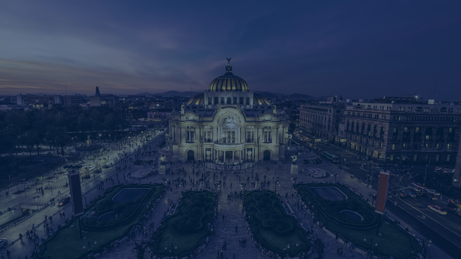 Grand ornate cathedral illuminated at dusk with symmetrical plaza and pathways leading to it
