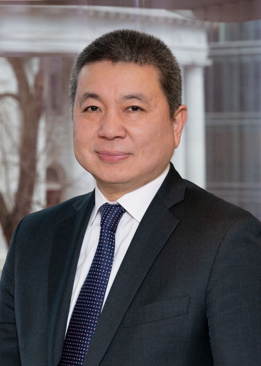 Professional headshot of an Asian businessman in a dark suit and tie