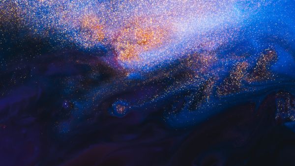 An image of a galaxy or sparkles with a mix of blue and purple colors, leading to a Strategic Philanthropy Newsletter for the Milken Institute.