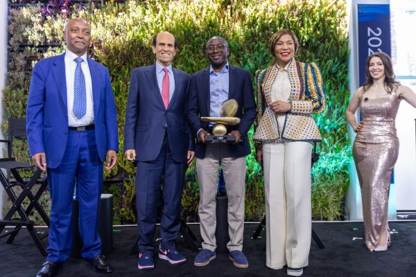 An image of Milken-Motsepe prize winners standing and holding an award next to Michael Milken of the Milken Institute. (Left to right) Patrice Motsepe, Africa Rainbow Minerals; Michael Milken, Milken Institute; Ola Oyetayo, Verto; Precious Moloi-Motsepe, Motsepe Foundation; and Emily Musil, Milken Institute.