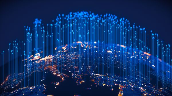Stylized digital rendering of a glowing Earth from space, with Europe and surrounding regions lit up in bright points of light representing connectivity. Blue binary code (ones and zeroes) and data lines extend upward from the surface, symbolizing global digital infrastructure, data exchange, and financial technology networks.