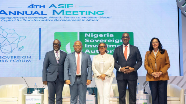 Group of five speakers standing on stage.