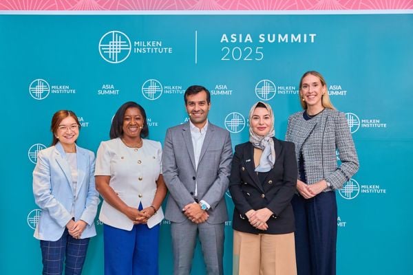 Five people stand in front of a teal backdrop featuring the Milken Institute and Asia Summit 2025 logos.