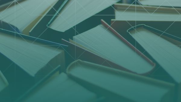 Overhead view of open and closed books layered together, creating a textured pattern that represents knowledge and learning.