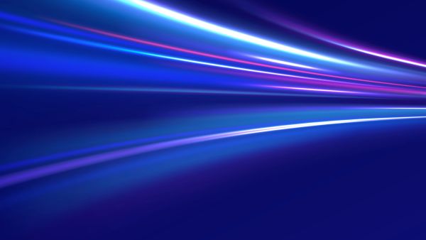 An abstract digital graphic featuring vibrant streaks of blue, cyan, and magenta light moving horizontally across a dark blue background, creating a sense of high speed and motion blur.