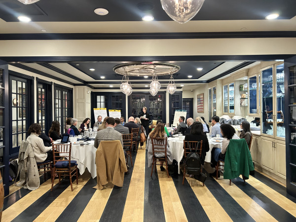 Elegant event space with guests mingling on black and white striped flooring under ornate ceiling