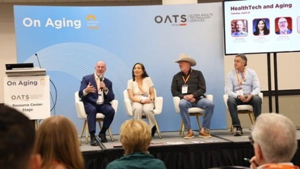 Panel discussion on aging with four speakers seated on stage before an audience