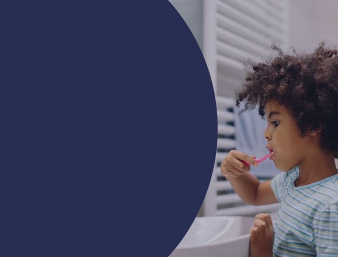 A child brushing their teeth at a window