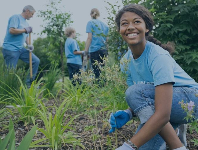 people working gardening in field together smiling