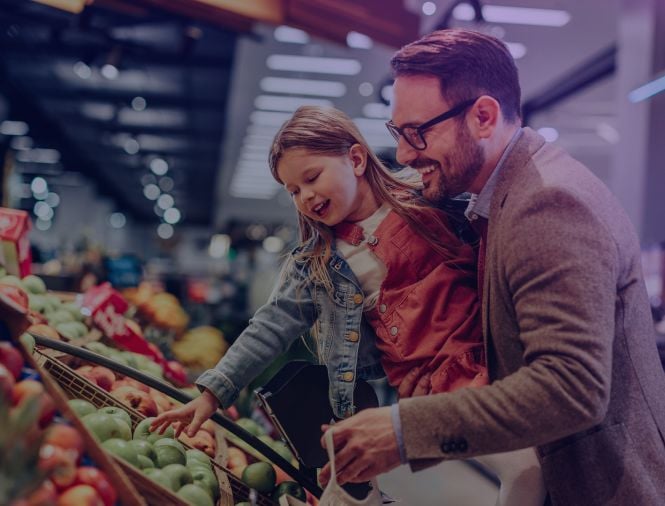 A dad and daughter shop for fresh produce