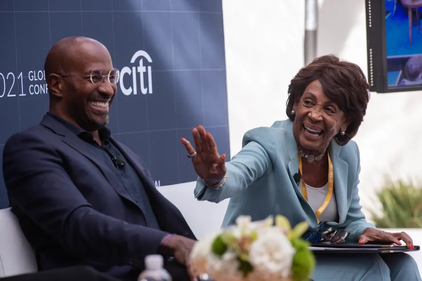 woman sitting next to a smiling man waving