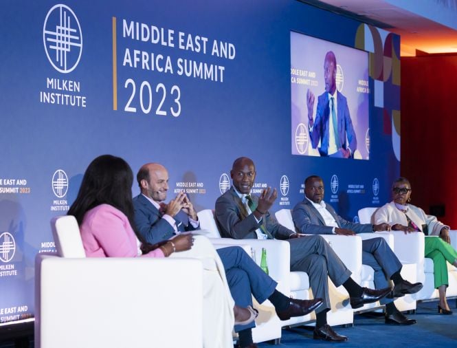 A group of panelists sit on stage at an event having a discussion