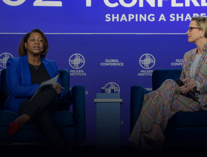 Two women interview each other on stage during an event