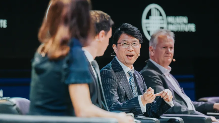 people sitting on stage at a conference