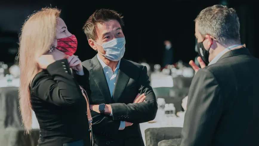 three people wearing masks having a conversation