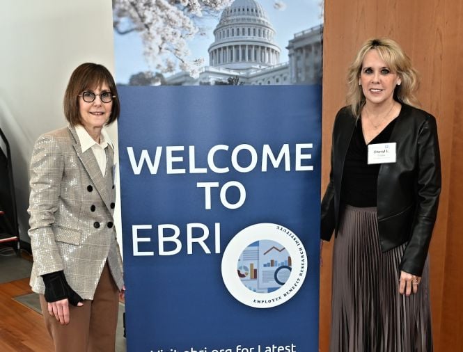 Two women stand on either side of an event pop-up banner