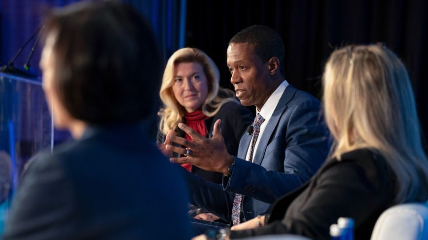 people in deep conversation on a public finance forum panel