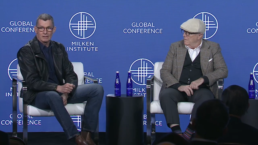 An image of two men sitting on stage at the Milken Institute's Global Conference 2023 and speaking about Gun Violence prevention and solutions.