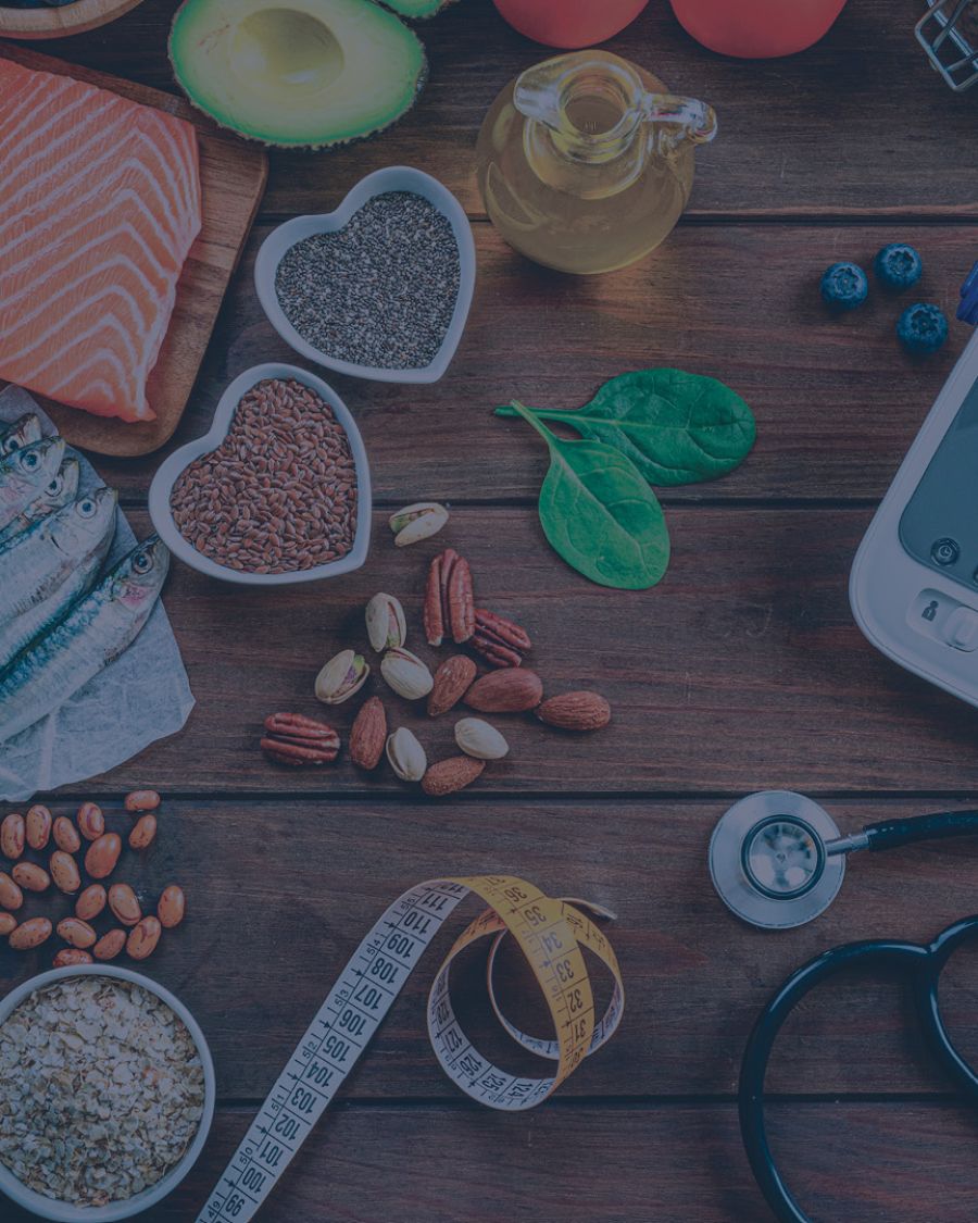 Fish, produce and a blood pressure monitor on a wooden surface