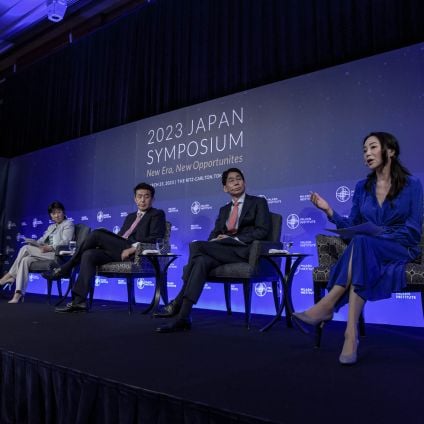 A group of panelists sit on stage during an event