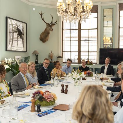 Photo of speakers at a table for the Milken Institute