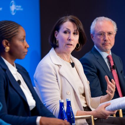 Panel of five professionals seated at a conference table during a discussion event