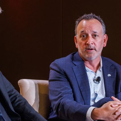 Two business professionals in suits having a conversation while seated