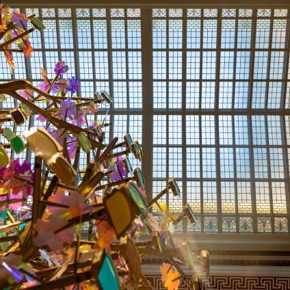 The golden Dream Tree rising toward the skylight in the Hall of Generations