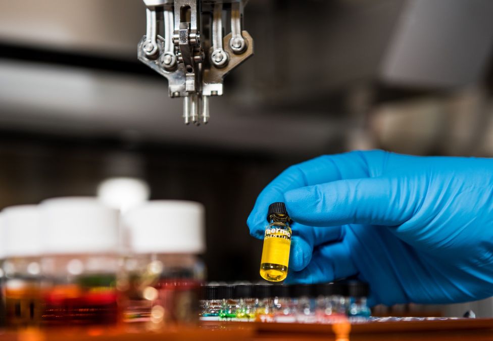 gloved hand holding a vial