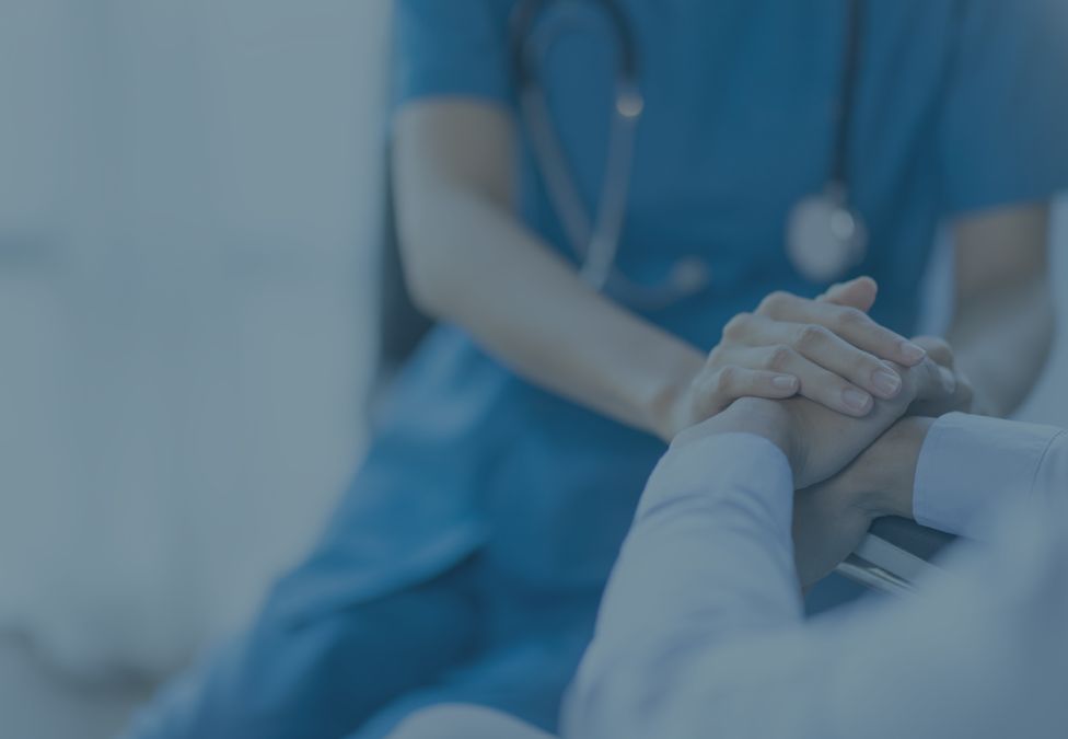 a healthcare professional holding a patient's hand