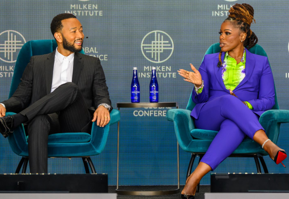 dark skinned male and female celebrities seated on conference stage during a discussion