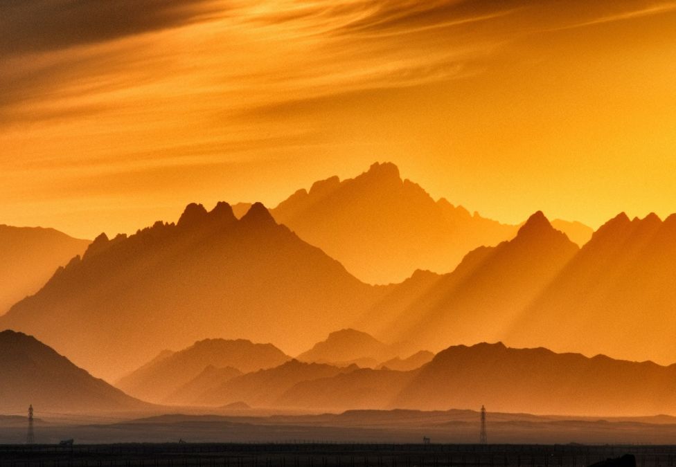 Mountaintops at sunset with an orange haze over them