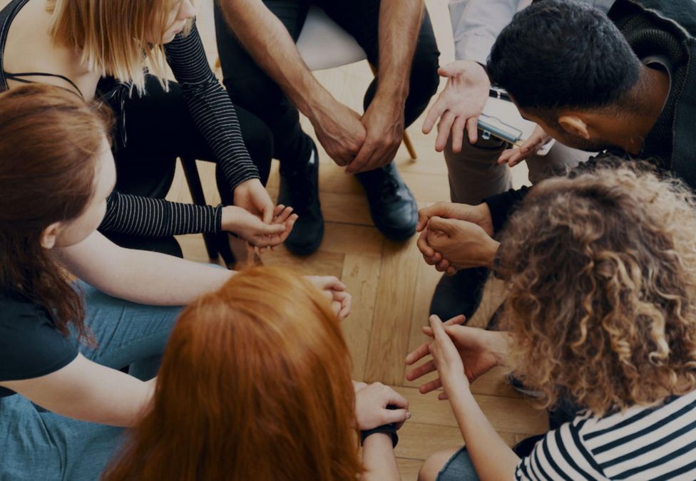 A group of people seated in what appears to be a therapy session
