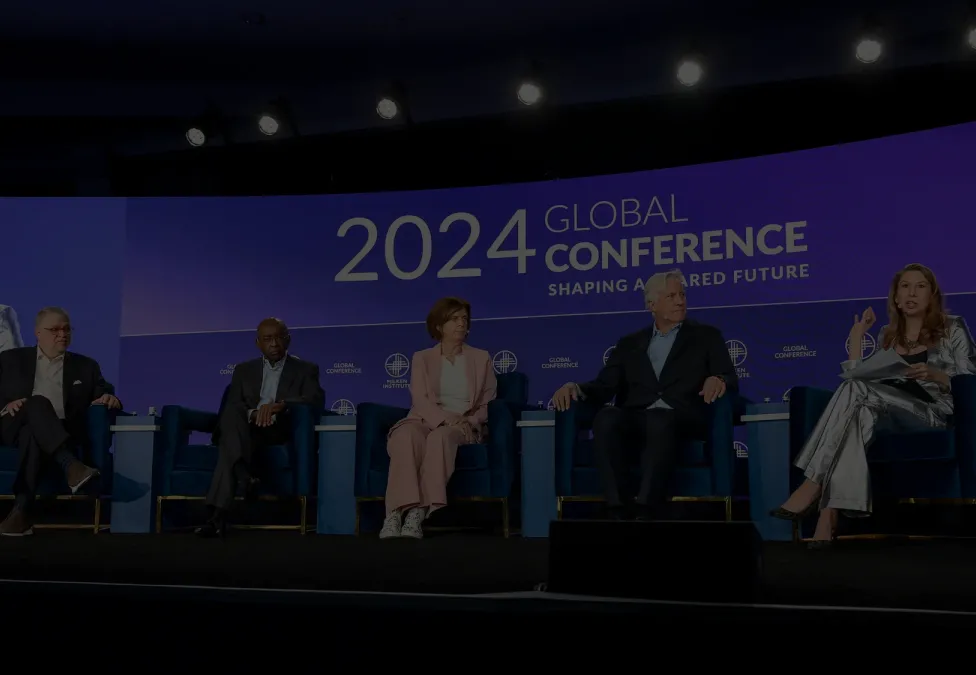 A panel of people speaking at a conference.