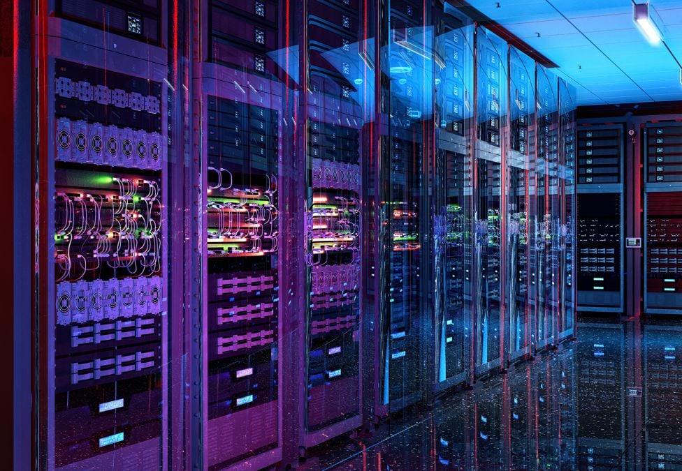 A server room featuring multiple servers with purple and blue-ish lights and various wires and buttons.